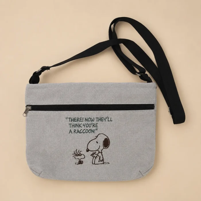 Grey printed cotton sling bag with adjustable black strap and front zip pocket