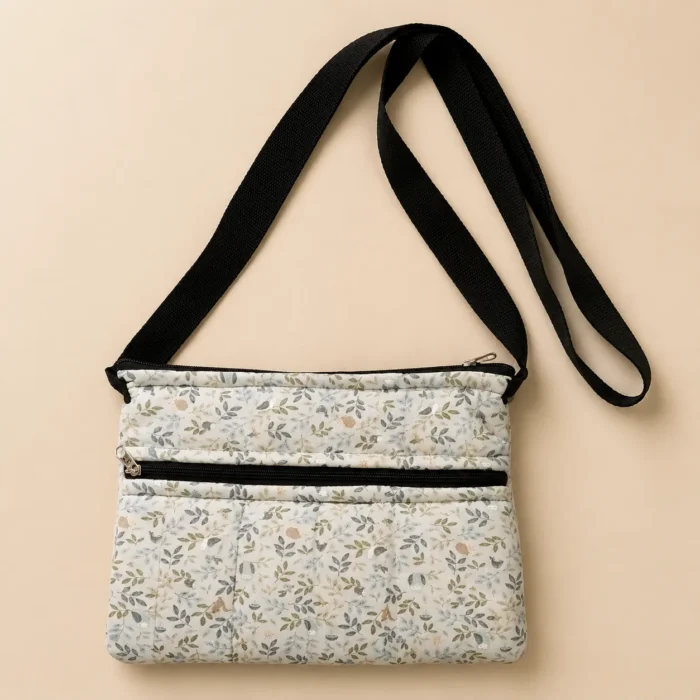 White floral printed sling bag with adjustable black strap and front zip pocket